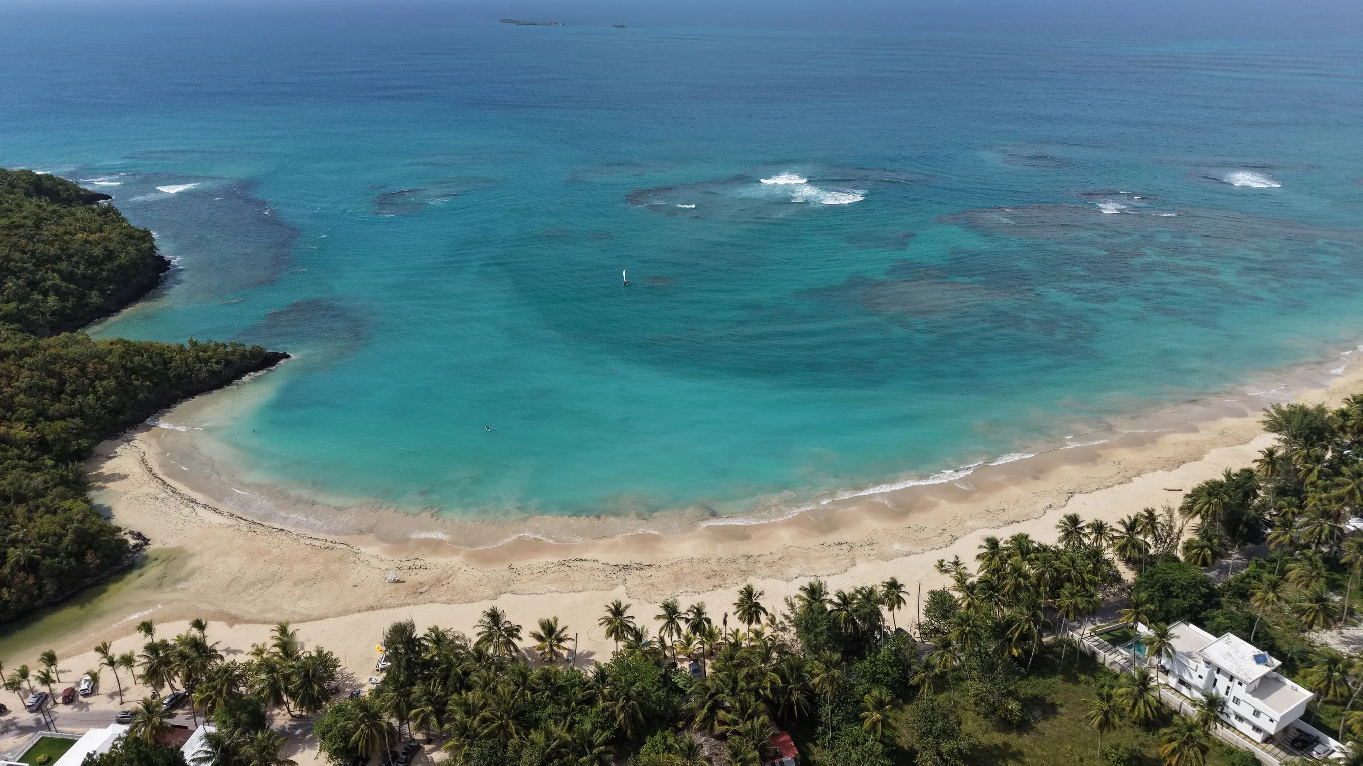 Vista aerea di una baia circondata da palme con barriere coralline sulla penisola di Samaná