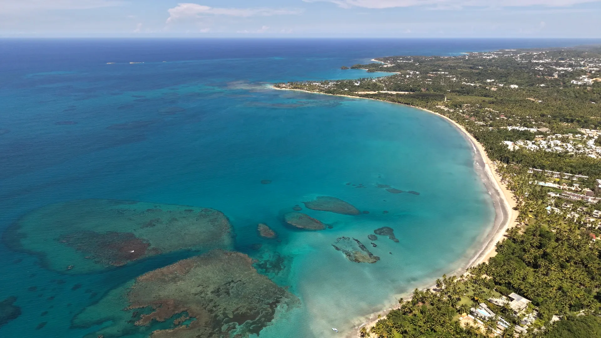 Aerial view of a Las Terrenas bay with its coral reefs and palm-lined shore